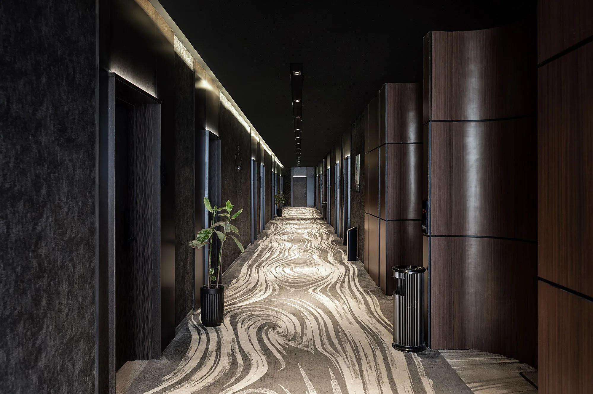 Rendering of a hotel corridor with a pale carpet pattern flowing between dark doors.
