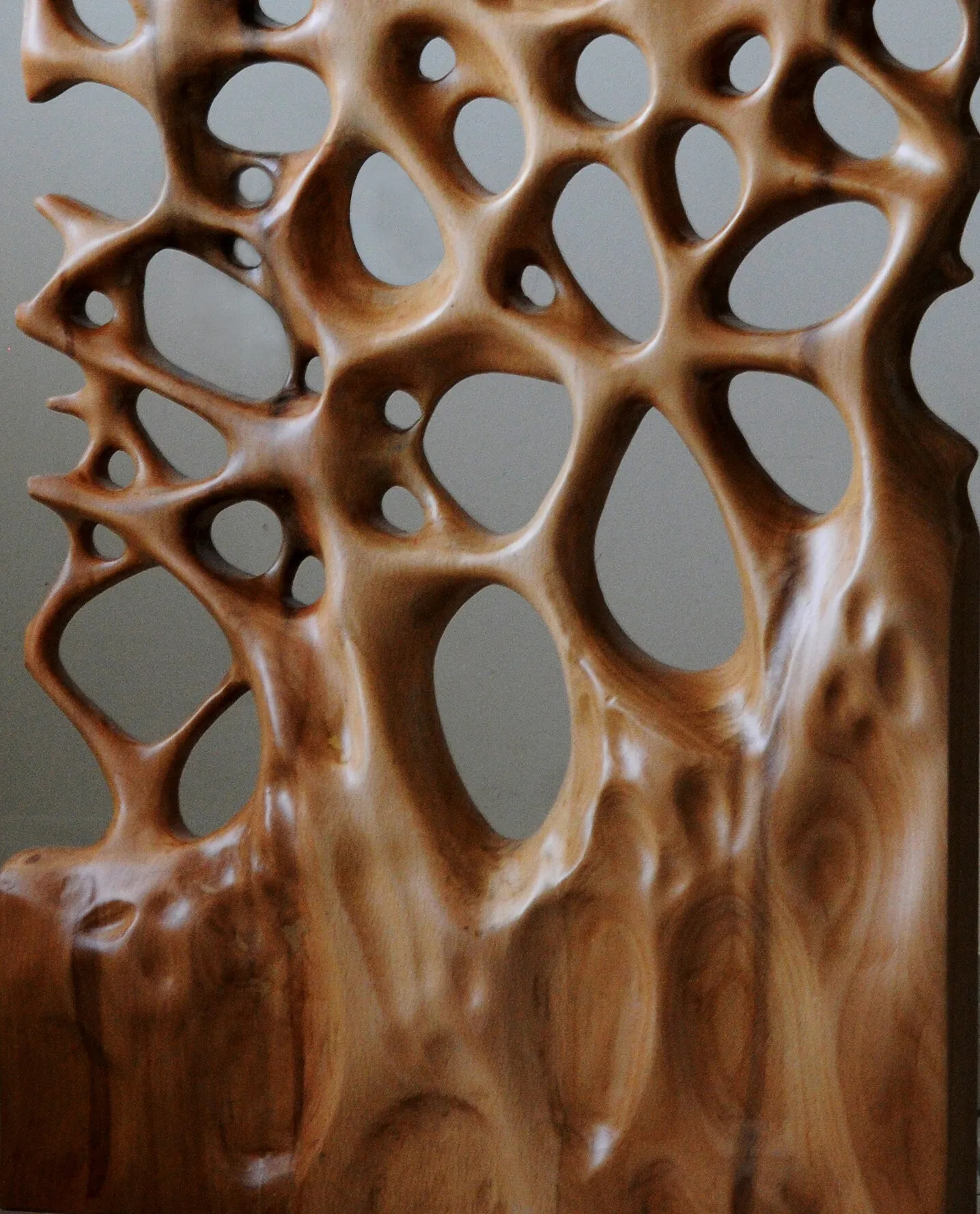A full carved wooden wall panel with branching edges and large rounded openings.