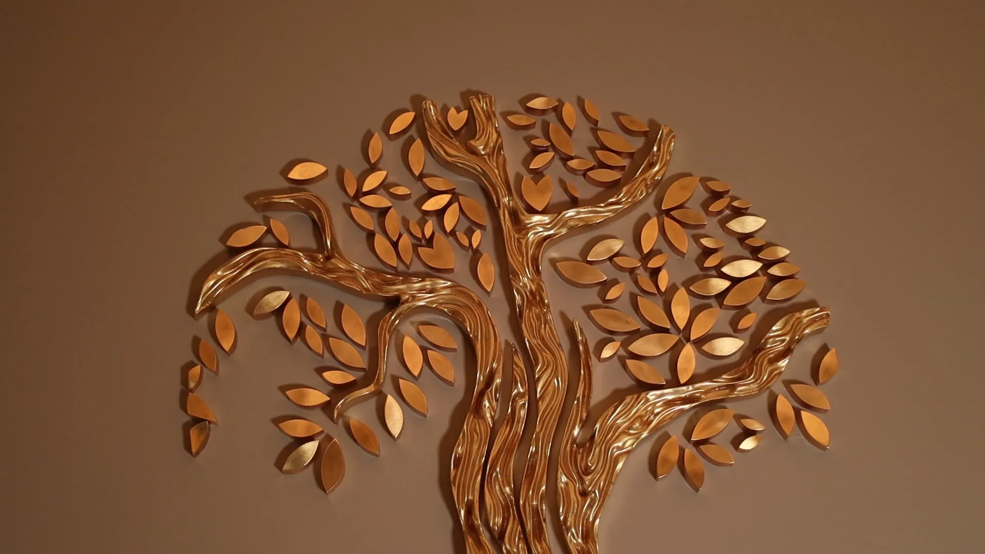 A gilded tree relief rises above the IL DON sign on a warm brown wall.